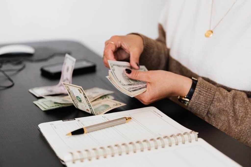 Person sorting cash on a table what are income share agreements