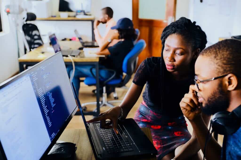 Woman showing a man something on the computer  what are income share agreements