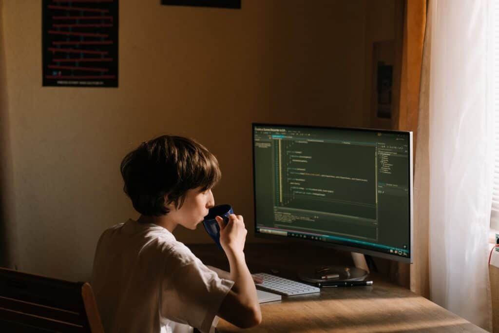 A man working on his desktop while drinking coffee web scraping with python