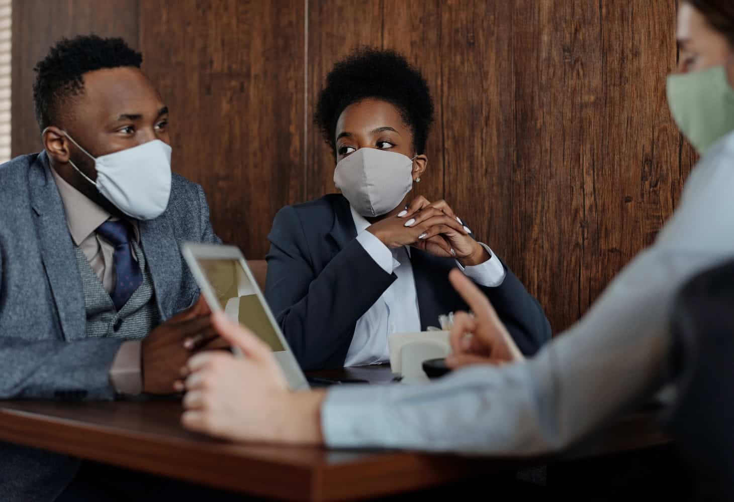 Several professionals in a business meeting wearing face masks. Essential Product Ownership Skills and Certifications
