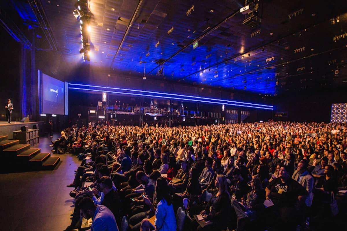Hundreds of data science professionals attend a data science conference in a massive room.